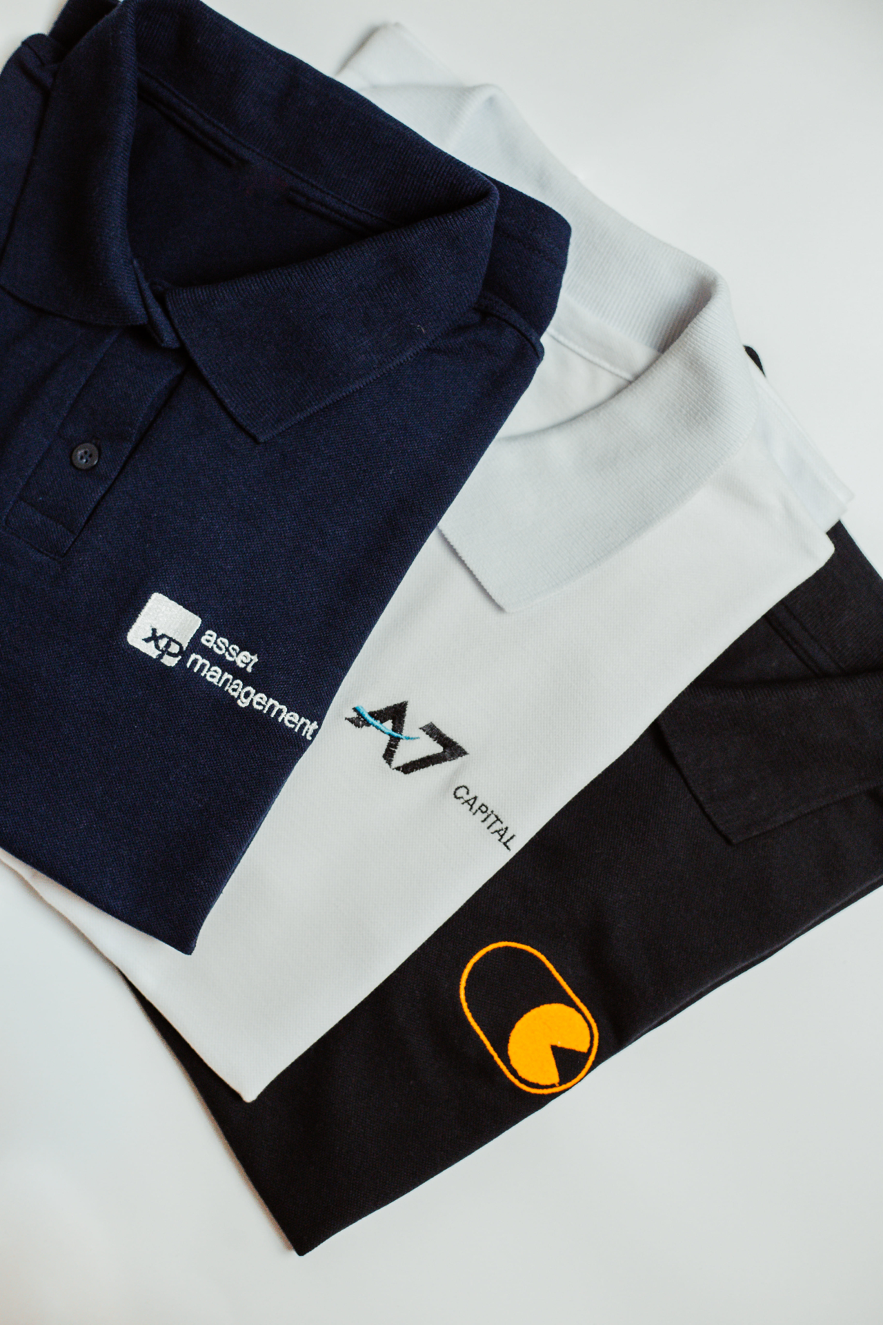 Polos navy, off-white e preta empilhadas